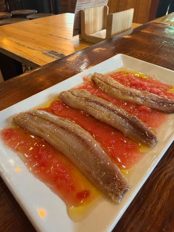 Anchoas sobre tomate rallado con aceite de oliva